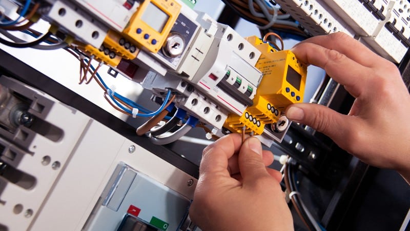Detailaufnahme Hände an elektrotechnischer Anlage